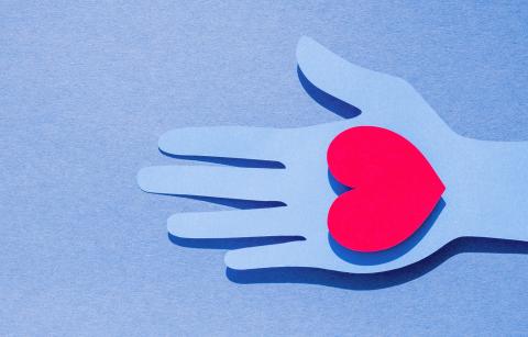 flat-lay-paper-hand-holding-heart-with-copy-space